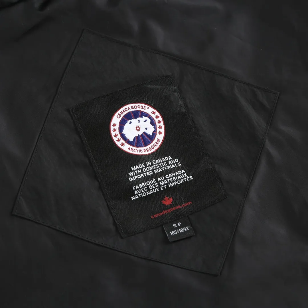 P740 Big Goose Logo Hooded Down Vest Fabric selection: The use of high-quality protective nylon fabric not only enhances the wear resistance of the surface, but also takes into account wind resistance, ensuring excellent performance in various harsh weather conditions.  90 national standard high-quality white duck down: selected high-loft down, weighing 170g, light and warm, with excellent temperature locking performance and good resilience.  Three-dimensional quilting process: Precision thread reinforcement to prevent velvet drilling and ensure that the fluffy and resilient elasticity lasts as new.  Details: Use polyester as the base for woven webbing, and use high-precision computer embroidery to decorate the brand letters on the webbing. The edges of the pattern are clear, the stitches are fine and even, and multiple layers of embroidery threads are stacked to enhance the three-dimensional effect. Accessories: One-to-one customized logo One-to-one customized zipper pendant One-to-one customized hem elastic buckle One-to-one customized snap button SIZE: S M L XL
